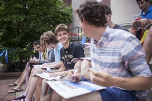 Students sitting on the steps completing an activity about the Community Creed.