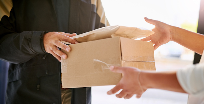 Shot of a courier making a delivery to a customer