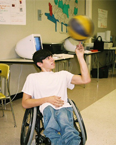 student in wheelchair twirling basketball on his finger