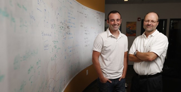 portrait in front of whiteboard filled with equations