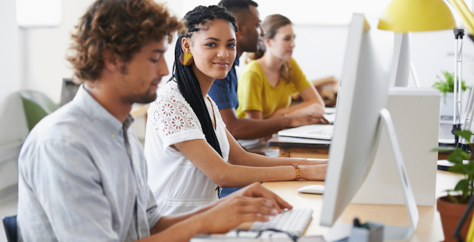 diverse young adults working at computers