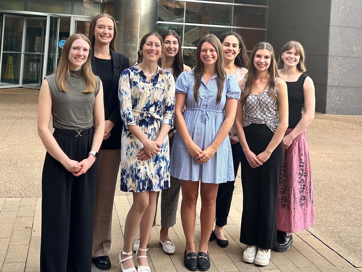 Members of the MGC class of 2026 pose for a photo outside a modern building.