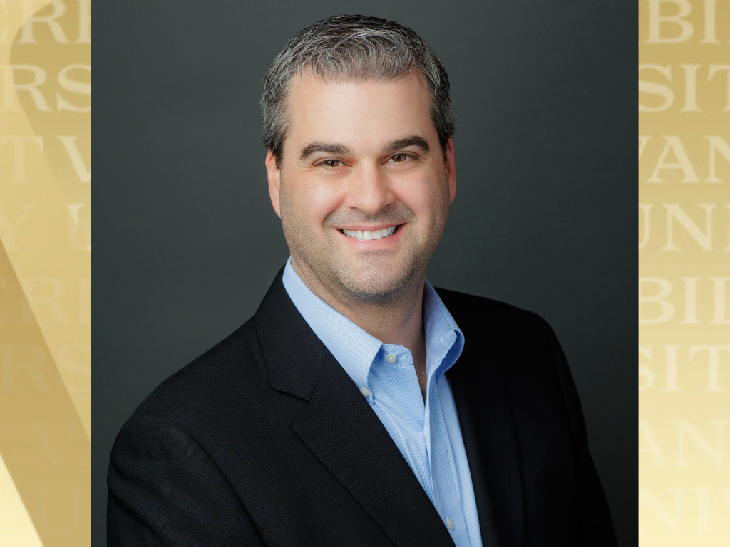 Alum Richard Gustin headshot with Vanderbilt gold background.