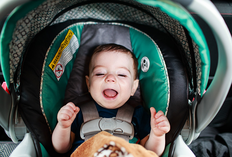 Baby sitting buckled into his car seat.