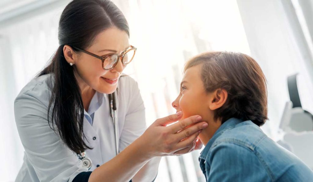 Pediatrician examining child for thyroid health.