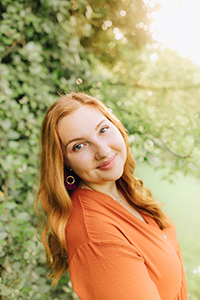 Emery Little standing outside with trees and grass in background