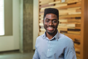 Alfred Prah in front of wood wall
