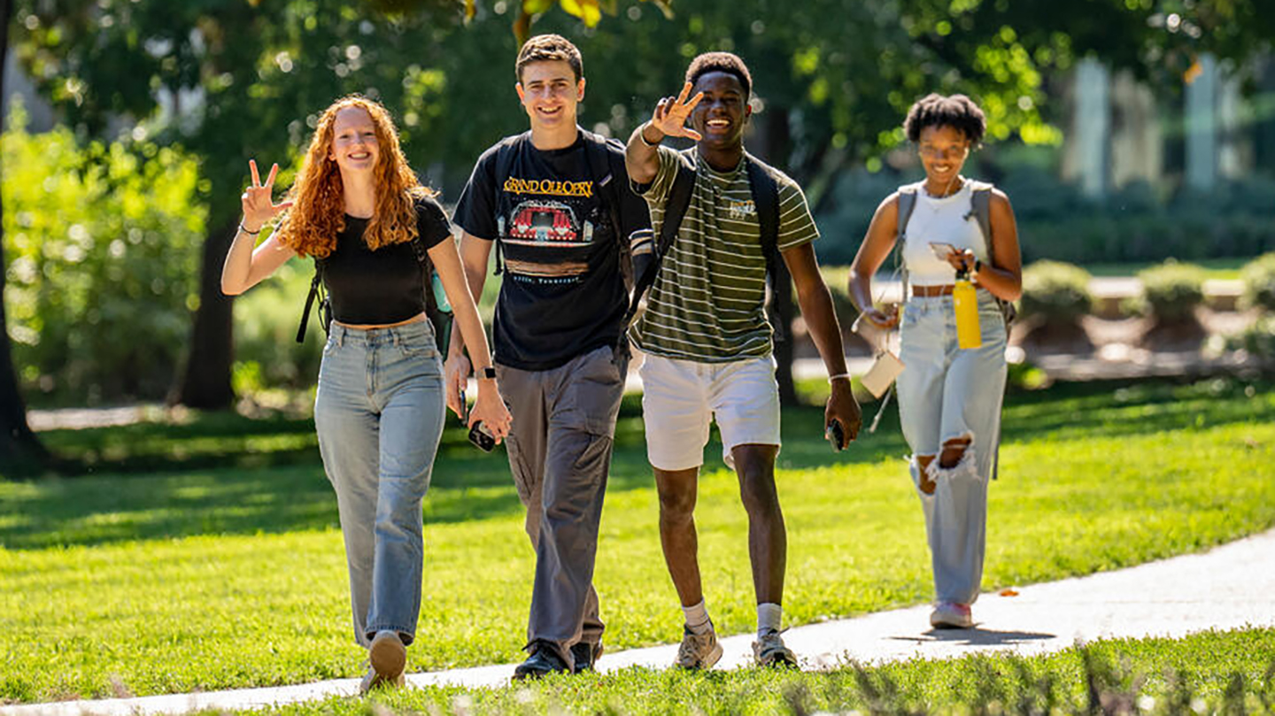 four students walk across Vanderbilt's campus