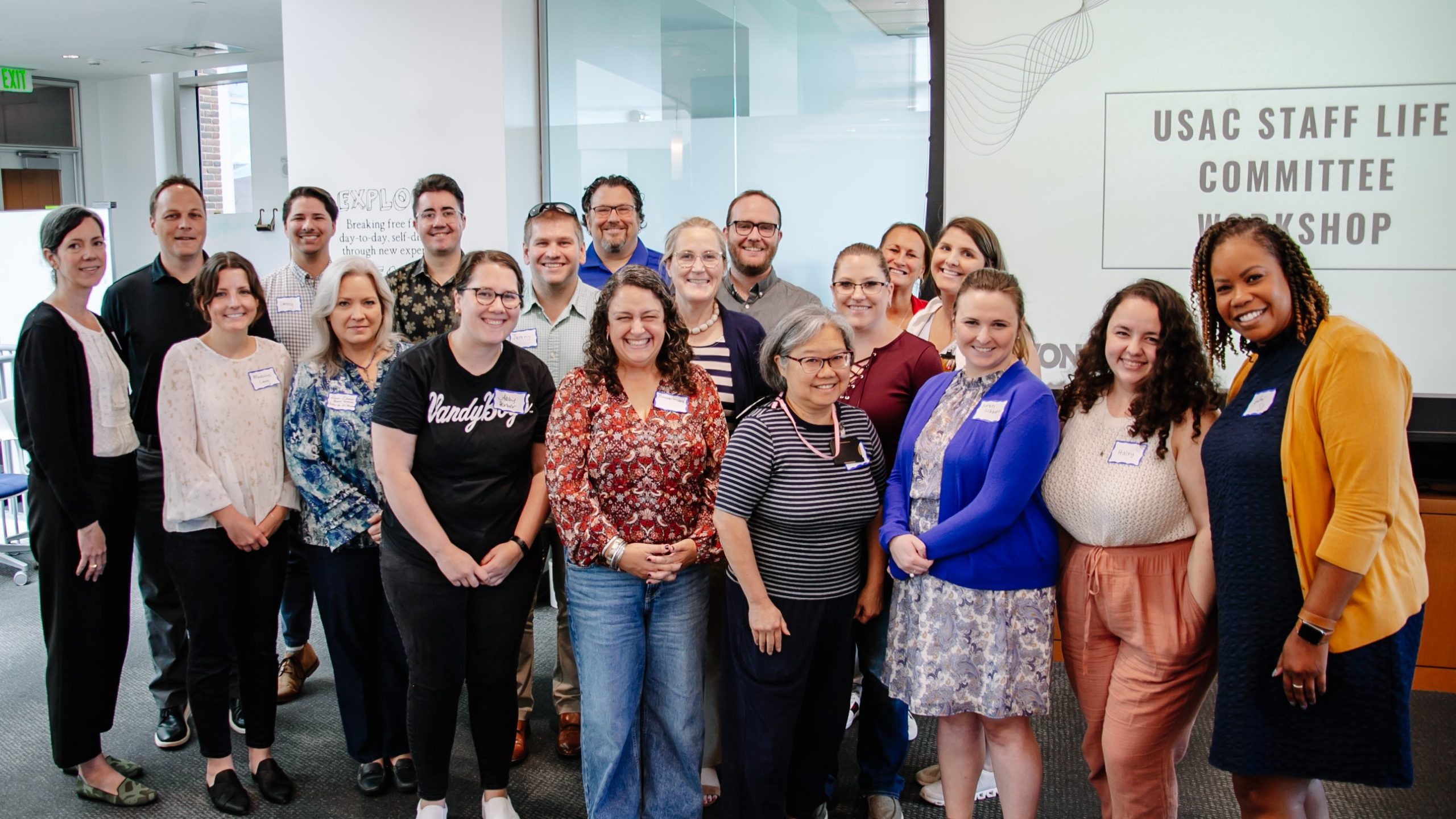 Staff life committee group in front of a power point slide