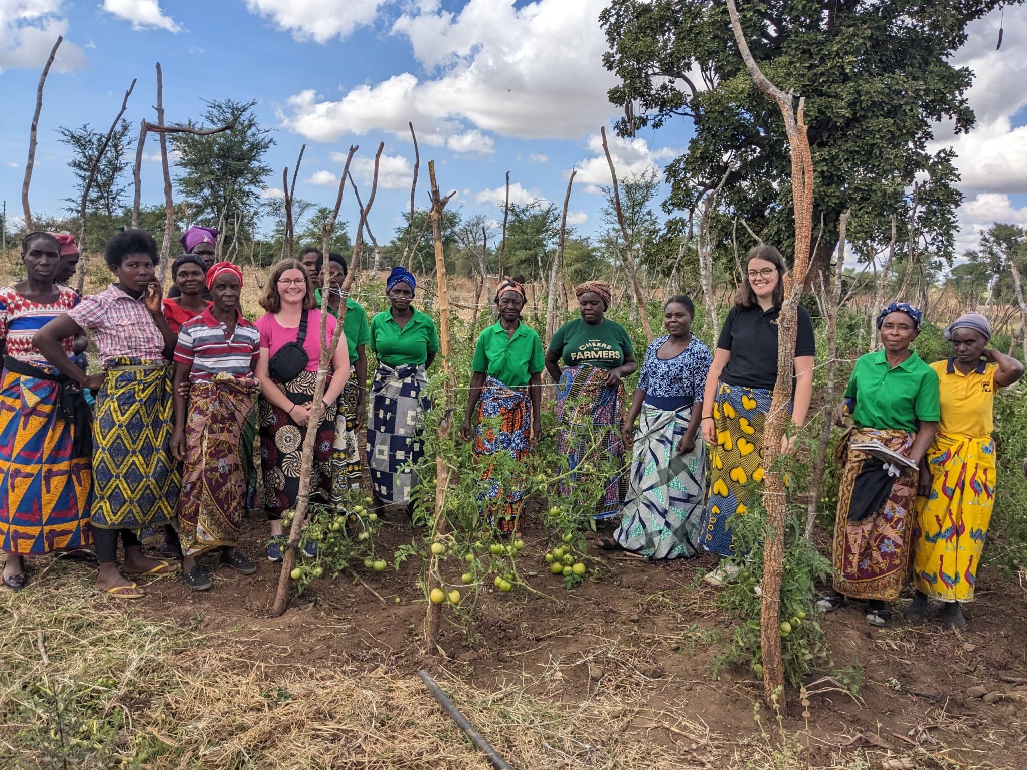 A large group of women on a farm pose together.