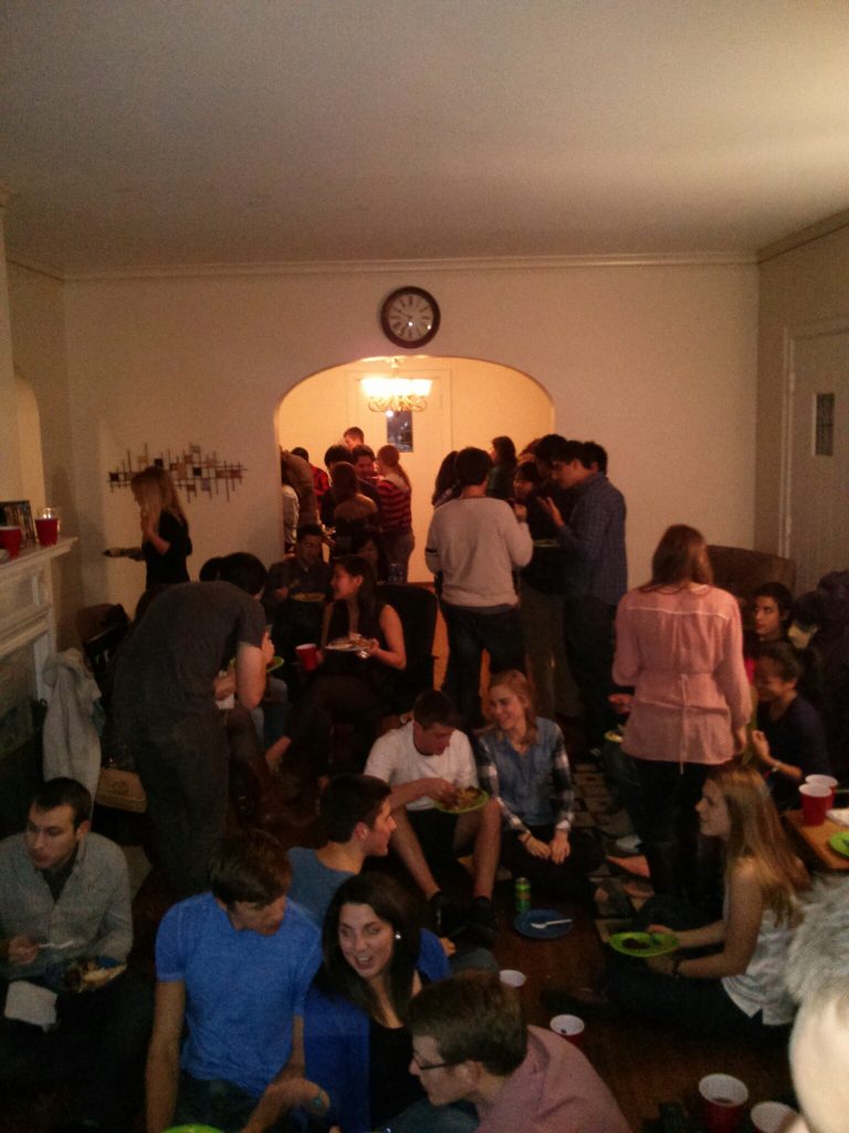 Many students gather in a home for Thanksgiving dinner in 2013.