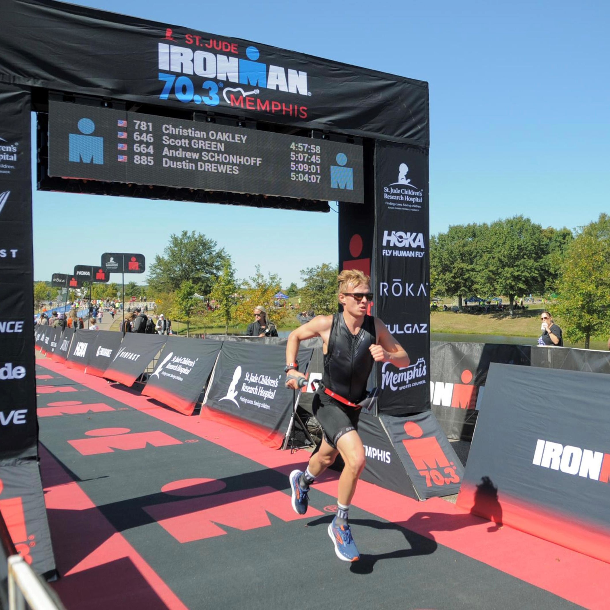 A man running under an arch that reads 