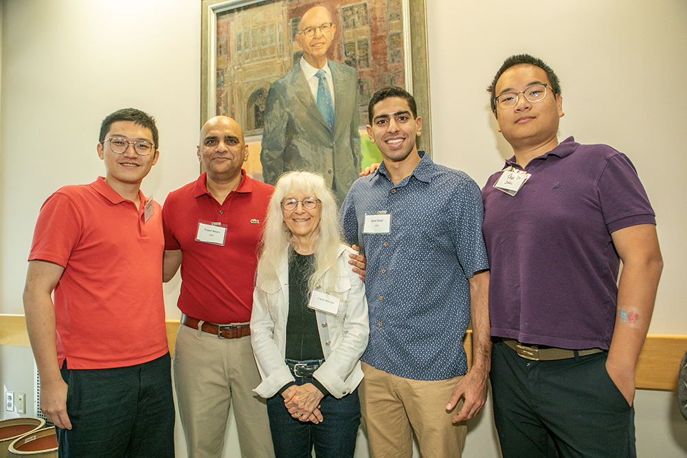People stand in front of Marentt portrait.