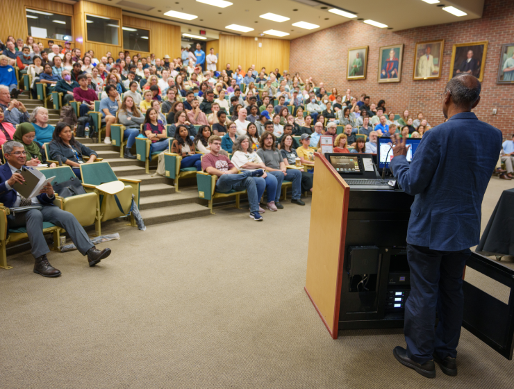 Man at podium addressing a room full of people