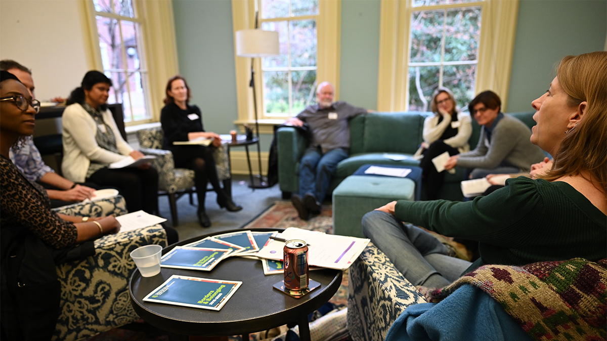 faculty members seated around a room having a discussion