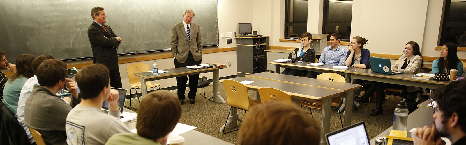 Professor Bill Purcell and former Nashville mayor Karl Dean speak to students sitting around tables in a public policy studies class
