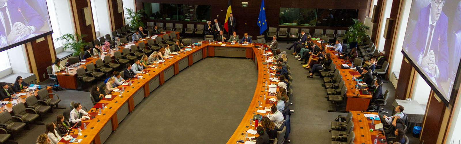 Public policy studies students, other college students, and officials seated at tables in a large room during the Junior Diplomat Forum