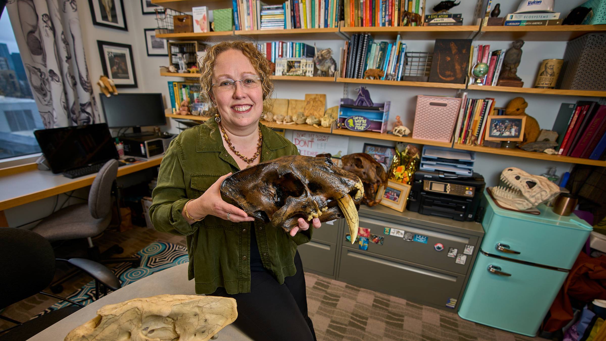 Larissa DeSantis in office holding large mammal skull