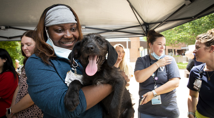 Sherita, Care Partner, hold puppy while Nashville Humane Association (NHA) introduces Paws on the Plaza, an event in which the NHA will bring adoptable puppies to the VUMC Plaza. Although this is not an official adoption event, all puppies are available for adoption through NHA following the event. While NHA offers Bark Breaks throughout the Nashville/Middle Tennessee area, we are thrilled to be the first hospital to enter this partnership. Photos by: Susan Urmy