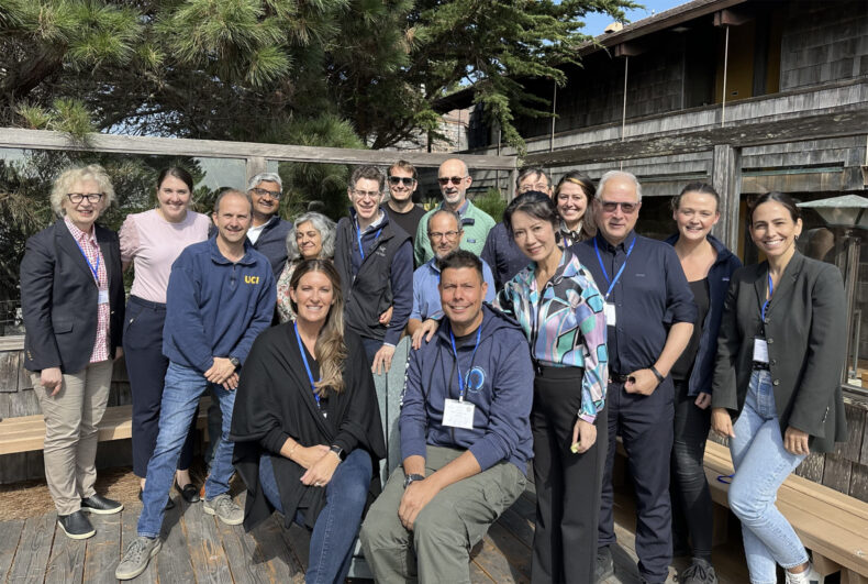 Brooke Emerling, PhD, and Raymond Blind, PhD (seated, in foreground) at a 2023 scientific symposium they organized. Standing next to Blind is Hua Ya, PhD, from the City of Hope Comprehensive Cancer Center. Behind him in the light blue shirt is Emilio Hirsch, PhD, from the University of Torino, Italy.
