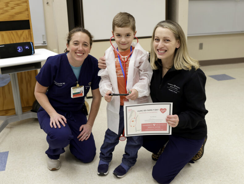 Tara Overbeeke, MD, left, poses for a photo with Jessica Mason, MD, and son, Myles, who received his white coat at VUMC EM Family Day. (photo by Donn Jones)