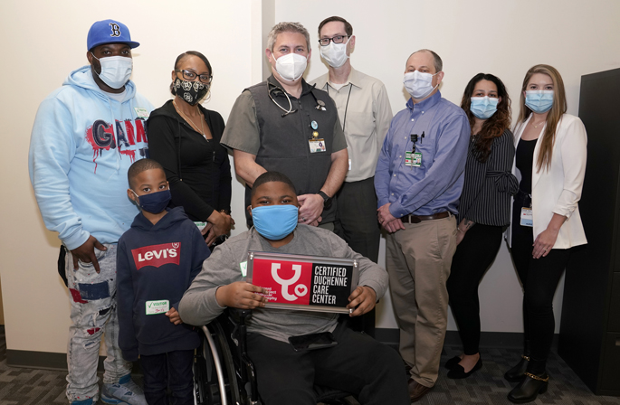 Javion Johnson, a patient at Children’s Hospital’s Duchenne Muscular Dystrophy Clinic, holds a plaque designating the clinic as a Certified Care Center. Others on hand include from left, his father Ronnie Johnson, mother, Xavier Verge, brother, J’zarion Williams, Andrew Sokolow, MD, Bryan Burnette, MD, Jonathan Soslow, MD, Kali Barbalena and Haleigh Southern, RN.