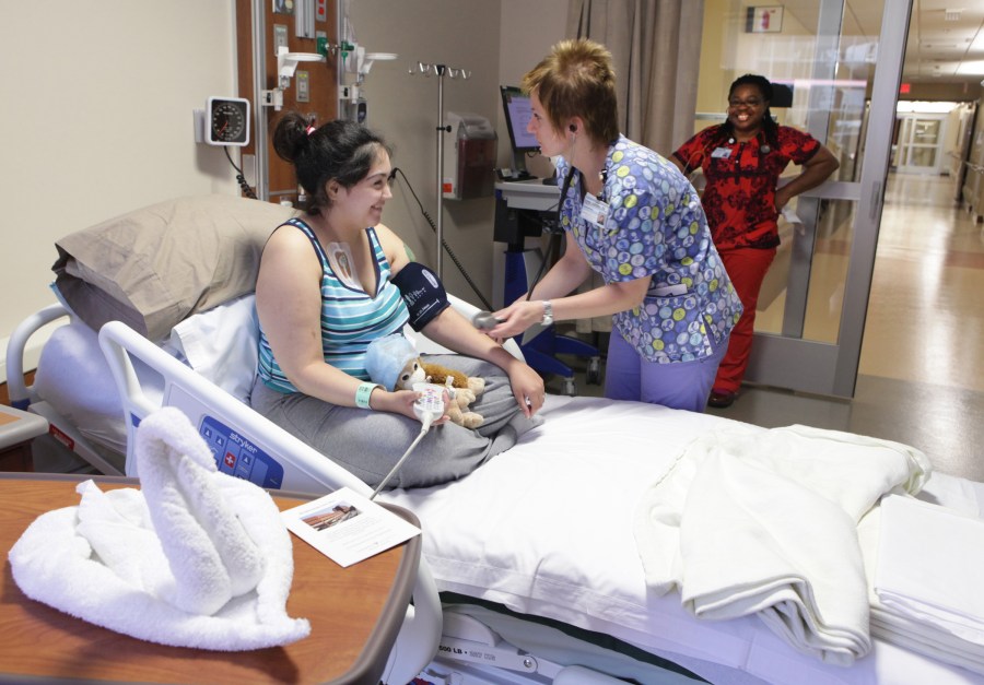 Patient Crystal Crunk has her blood pressure checked by Sylwia Zielinska, R.N., as Ng Ihejeto, R.N., looks on. (photo by Anne Rayner)