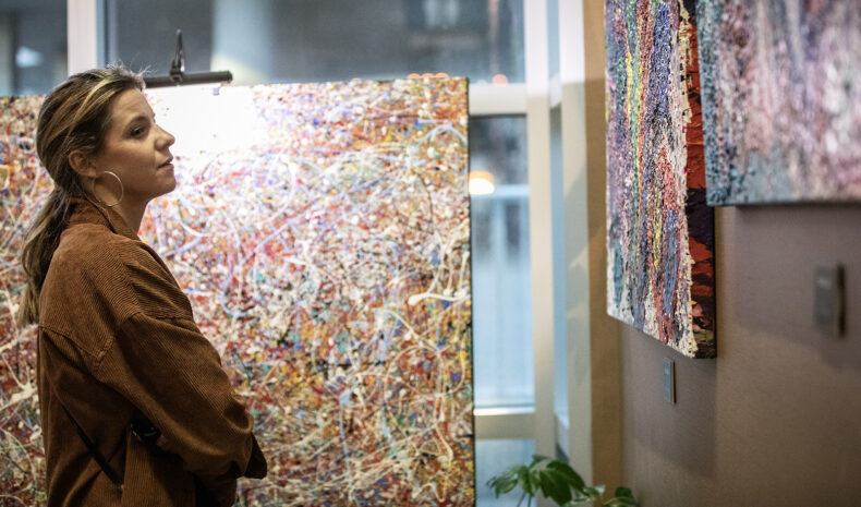 Liz Bohannon looks at paintings by Steven Snodgrass, MD, during a Nina Kuzina Gallery showing in the Vanderbilt Eyes Institute lobby. (photo by Erin O. Smith)