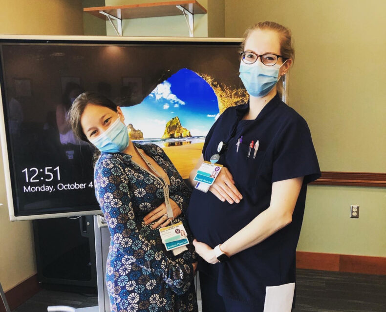 Jamie Pfaff, MD, right, and Katie Sunthankar, MD, both pregnant with their first children, pose for a photo at a residency conference.