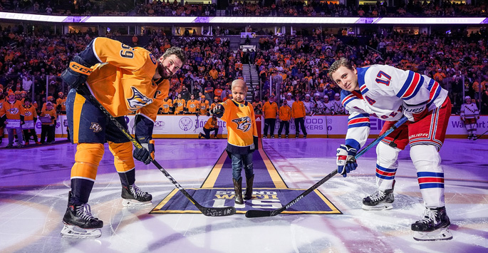 Children’s Hospital patient ambassador Katie Shepherd, who served as Mayor of Smashville during Hockey Fights Cancer, drops the puck with the Predators’ Roman Josi, left, and New York Ranger Jesper Fast.