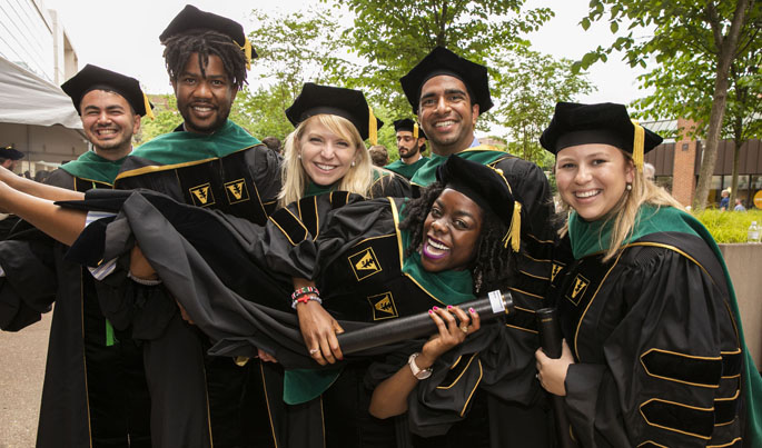 Jacqueline Harris receives a lift from fellow School of Medicine graduates, from left, Nick Baddour, Majaliwa Mzombwe, Jessica Lindsay Burris, Nikhil Chavali and Megan Shroder.