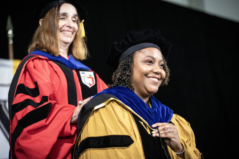 Maureen Gannon, PhD, left, hoods Darian Thomas Carroll, receiving her PhD in Molecular Physiology and Biophysics. (photo by Erin O. Smith)