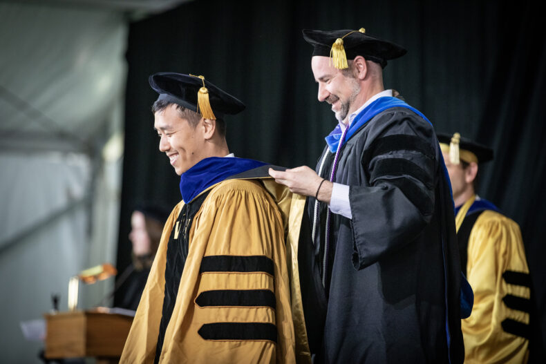 Xiaopeng Sun, receiving his PhD in Cancer Biology, is hooded by Justin Balko, PharmD, PhD. (photo by Erin O. Smith)