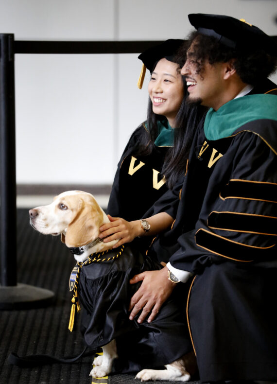 Cpl. Max, part of Vanderbilt University Police Department’s Community Canine Program, poses for a photo with School of medicine graduates X-zavyer Smith, MD, and Janice Im, MD. (photo by Donn Jones)