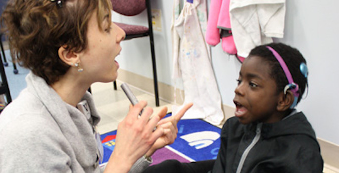 little boy with cochlear implant interacting with his teacher
