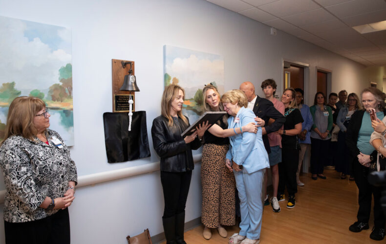 Suzanne Duckworth consoles her mother-in-law, Betsye Duckworth, as Stephanie Broderick, who worked with Matt Duckworth, reads words of appreciation from his colleagues. (photo by Susan Urmy)