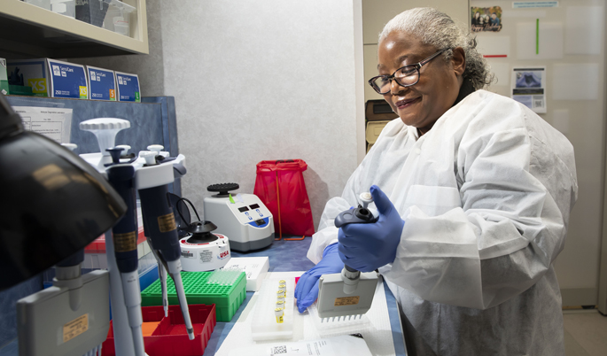 Medical laboratory scientist Gladys Garrison, MT, MS, loads reagents to prepare DNA samples for analysis in the VUMC Molecular Diagnostics Lab. 