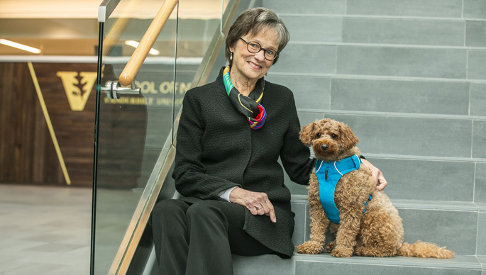 Mary Jo Gilmer, PhD, MBA, with Misha, a teddy bear goldendoodle that provides animal-assisted therapy. (photo by Anne Rayner)