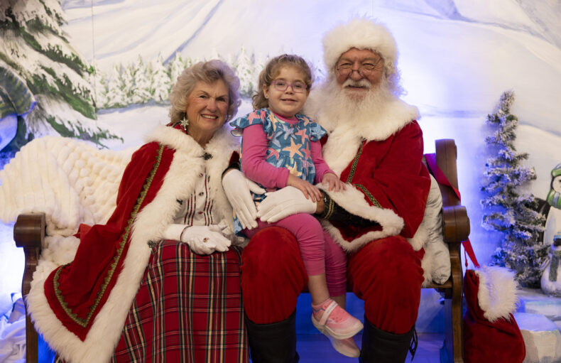 Kinsley Estes, 5, with Santa and Mrs. Claus during the visit. (photo by Erin O. Smith)