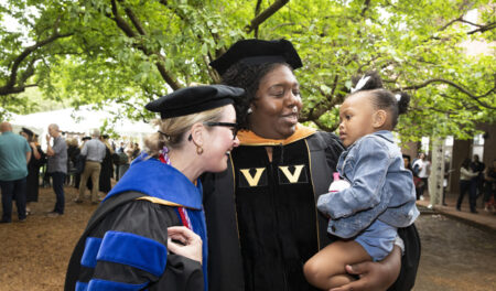 Betsy Kennedy, MSN, PNP, left, with DNP graduate Theresa Moore and her daughter, Zoey Woods, at the Nuring School ceremony.