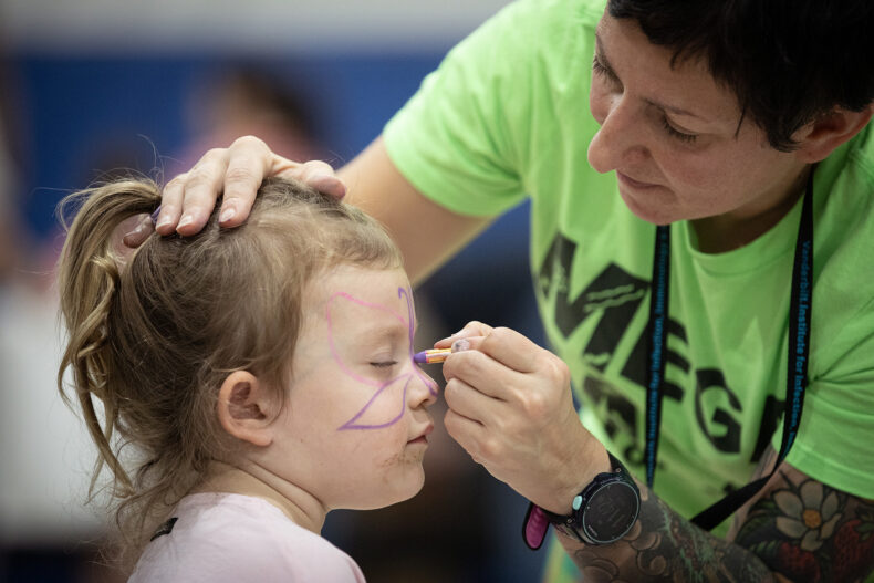 Cordelia Anderson, 3, gets her face painted by Maria Hadjifrangiskou, PhD, associate professor of Pathology, Microbiology and Immunology. (photo by Erin O. Smith)