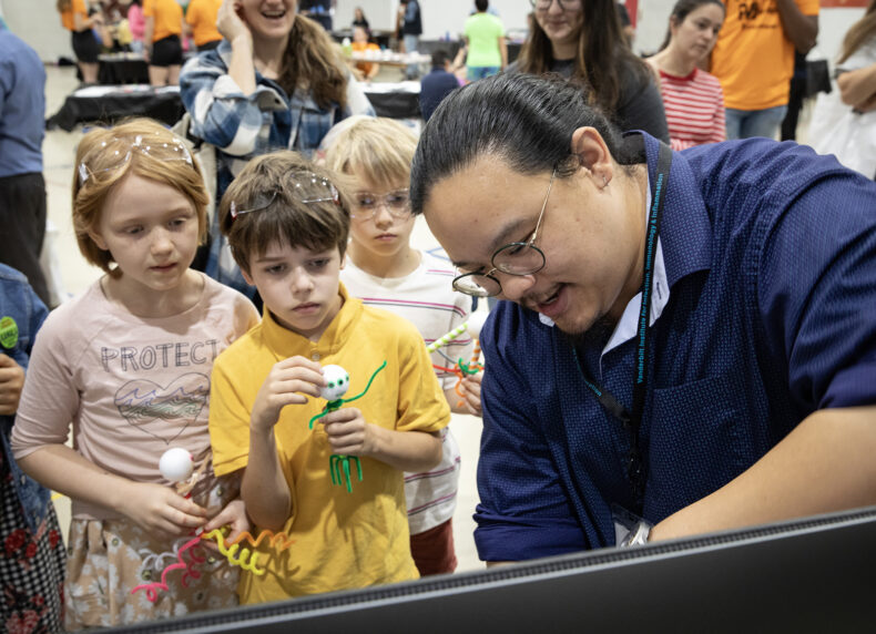 Jubilee Pond, 11, Timothy Pond, 9, and Preston Pond, 9, listen to Will Wan, PhD, assistant professor of Biochemistry, talk about bacteriophage. (photo by Erin O. Smith)