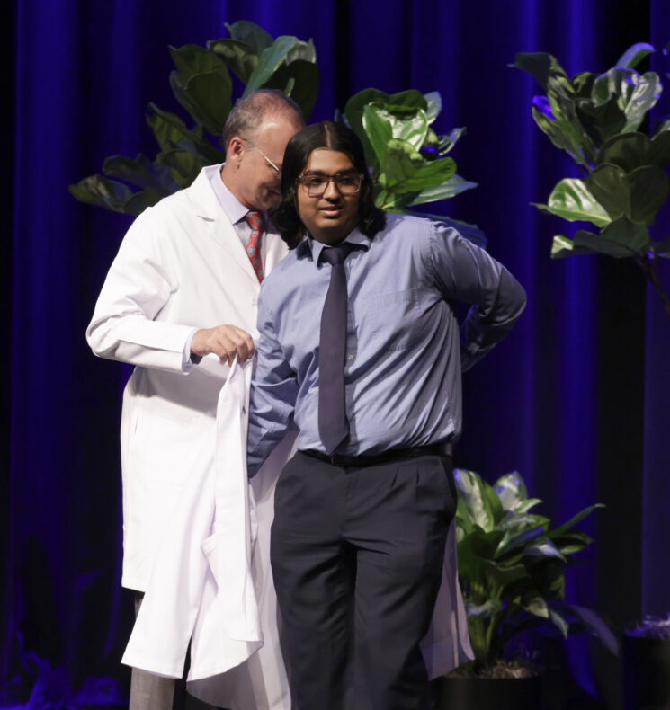 Saksham Saksena of Memphis, Tennessee, right, receives his white coat from Jeff Balser, MD, PhD. (photo by Donn Jones)