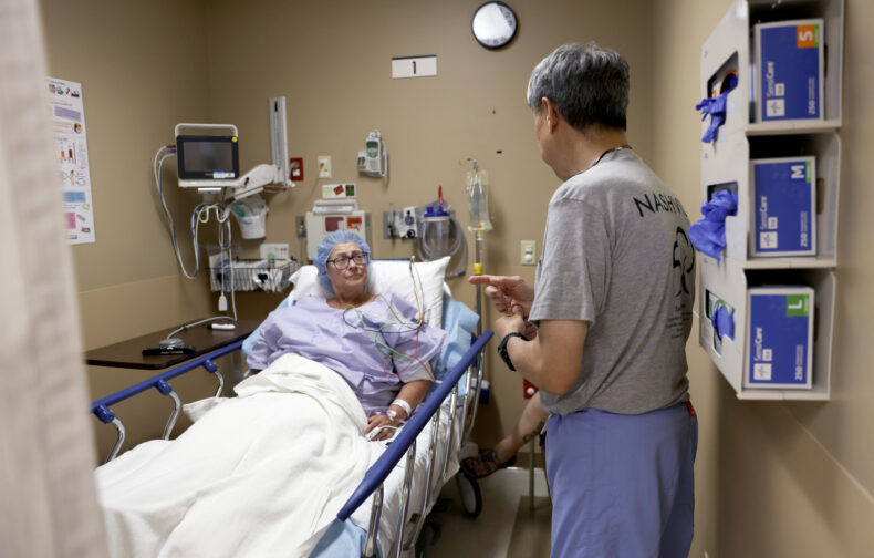 Christine Heyse talks with Donald Lee, MD, founding director of Vanderbilt Orthopaedics Outreach Day, before her carpal tunnel surgery. (photo by Donn Jones)