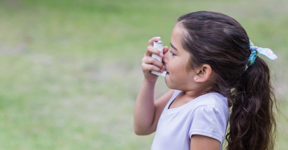 little girl using inhaler
