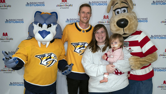 Nashville Predators mascot Gnash and goaltender Pekka Rinne, joined by Children’s Hospital mascot Champ, pose for a photo with patient Charlotte Merryman, 17 months, and her mom, Shelby, during a recent visit to Seacrest Studio at Children’s Hospital.