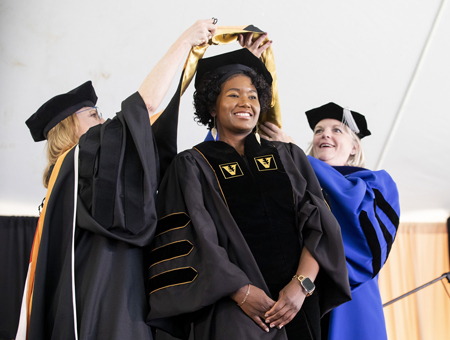VUSN graduate Viia Dionne Anderson receives her hood from Terri Allison, DNP, left, and Mavis Schorn, PhD.