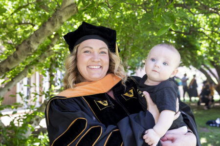 School of Nursing graduate Sarah Bray holds her son, Grayson, after the ceremony.