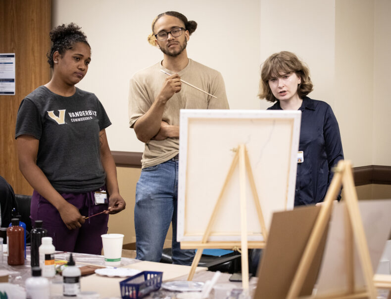 Patient Marcus Moore speaks with recovery coaches Dakota Austin, left, and Lillia Larson about his art. (photo by Erin O. Smith)