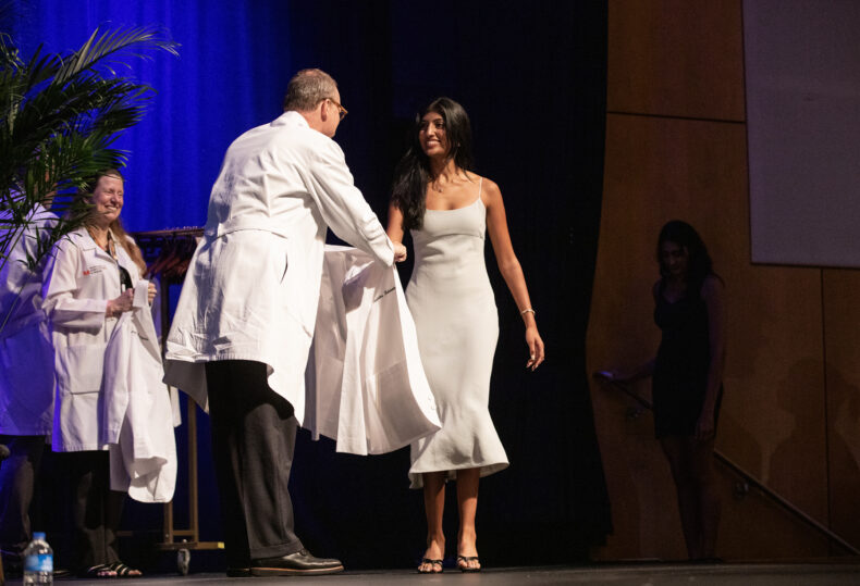 Rishitha Nalabothu receives her white coat from Jeff Balser, MD, PhD. (photo by Erin O. Smith)